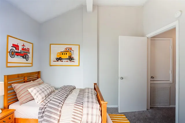 a bedroom with a bed and a painting on the wall