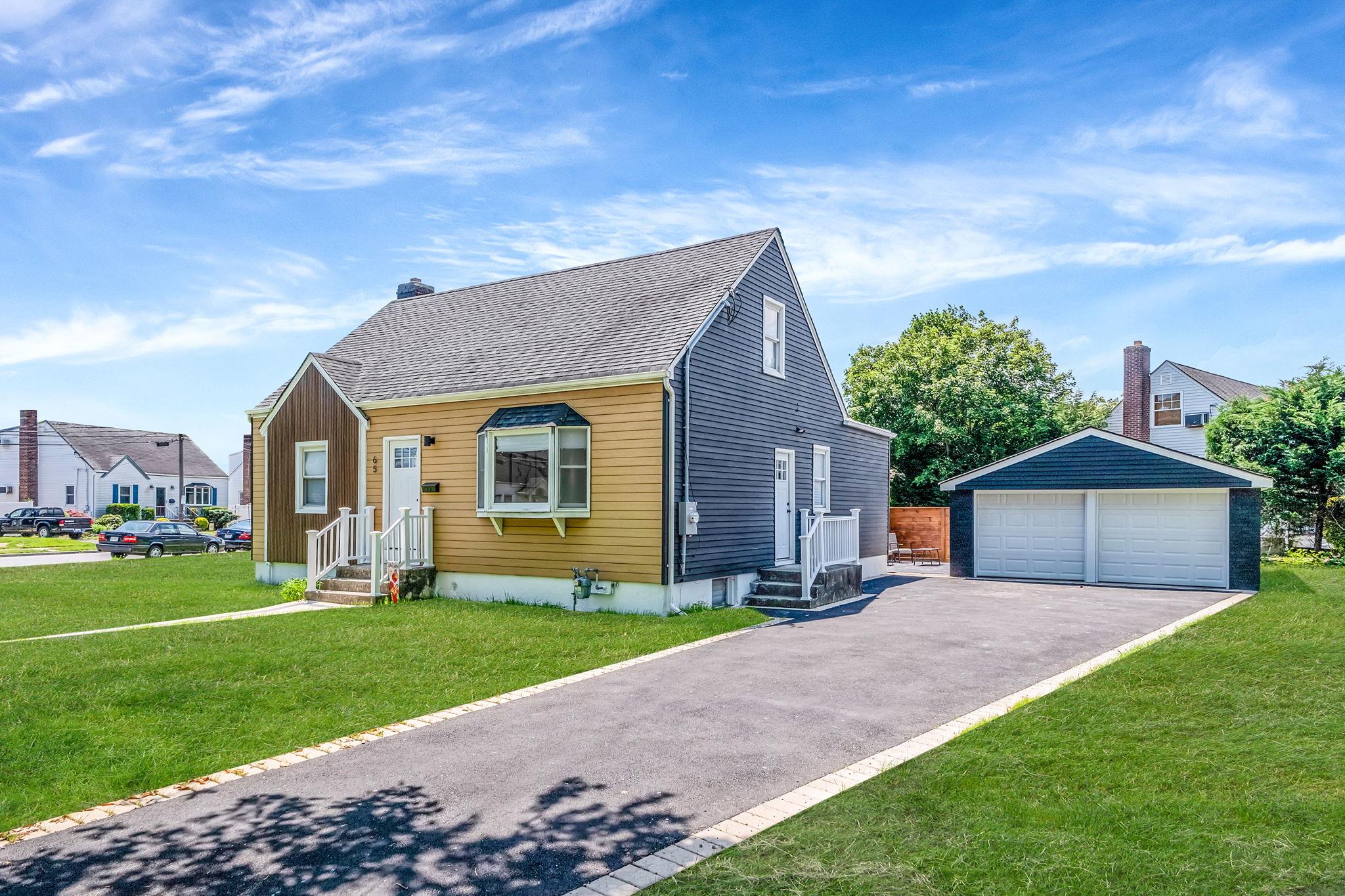 65 Sullivan Road Farmingdale, NY 11735 - Photo 1 of 1 View of front of property featuring a detached garage, an outdoor structure, a front yard, a chimney, and roof with shingles