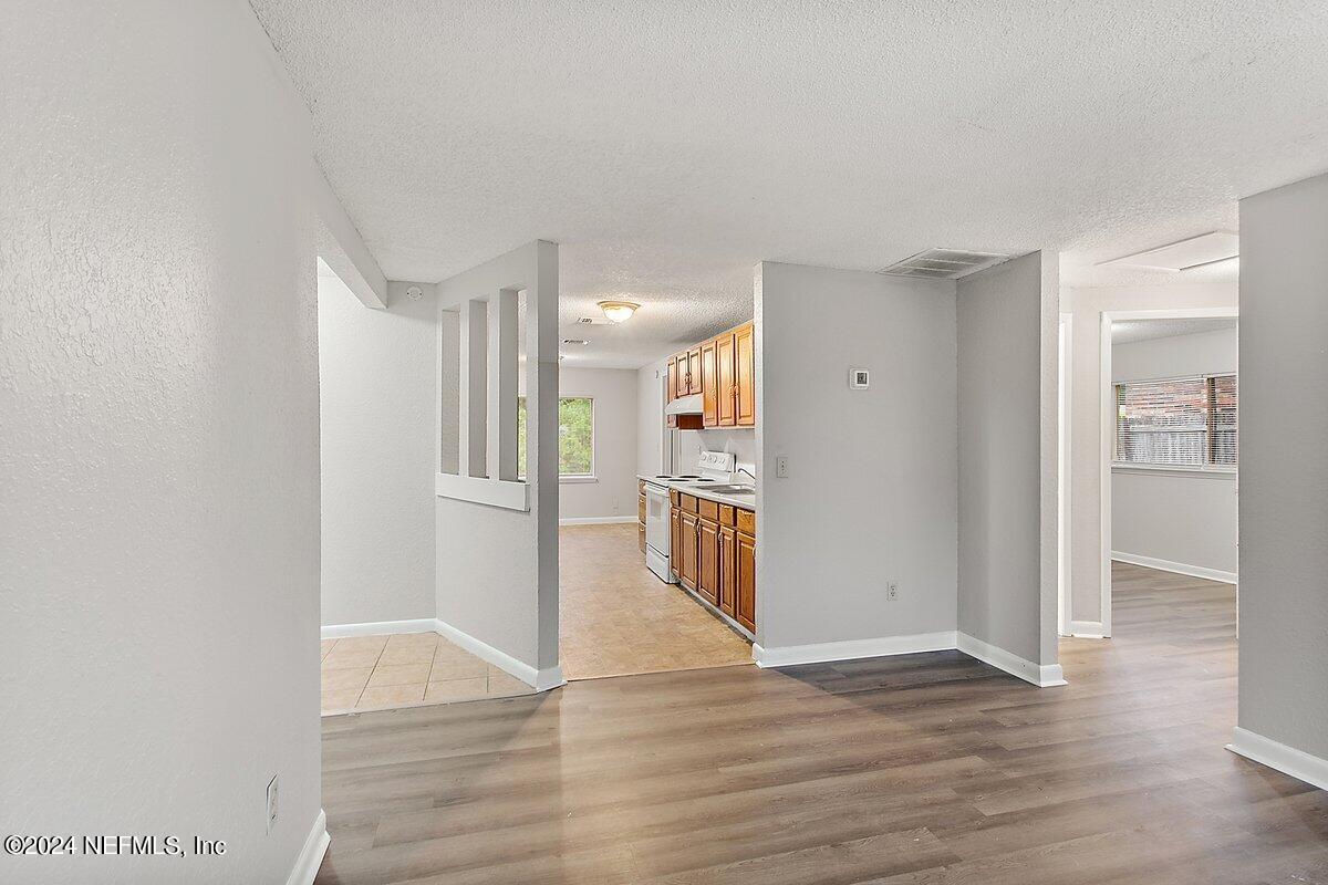 4371 Crossbow Road Jacksonville, FL 32208 - Photo 3 of 13 a view of a kitchen with wooden floor and a refrigerator