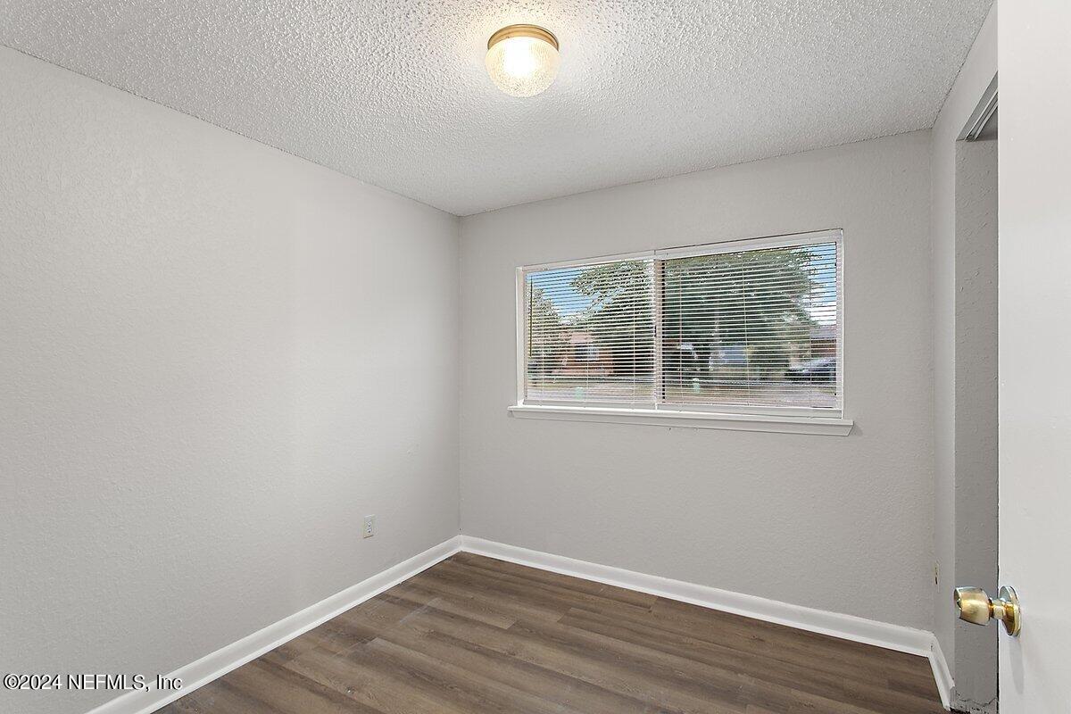 4371 Crossbow Road Jacksonville, FL 32208 - Photo 8 of 13 an empty room with wooden floor and windows
