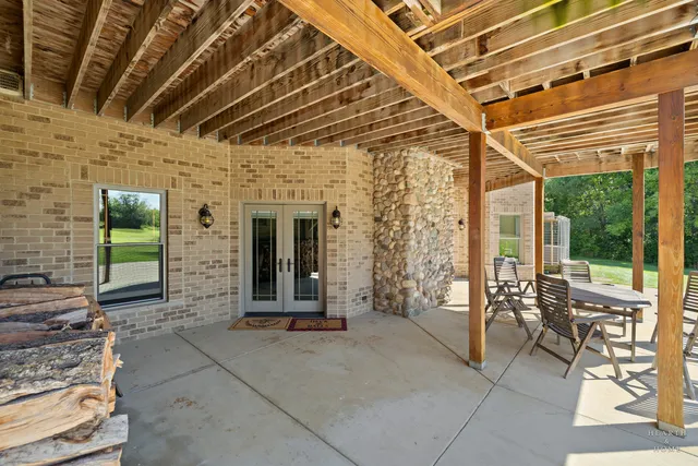 a view of a white house with large windows and a table and chairs