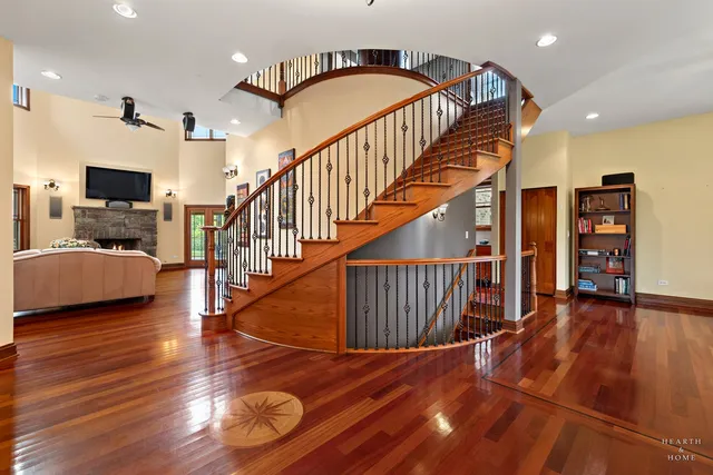 a kitchen with stainless steel appliances granite countertop a kitchen island a stove a sink a dining table and chairs with wooden floor