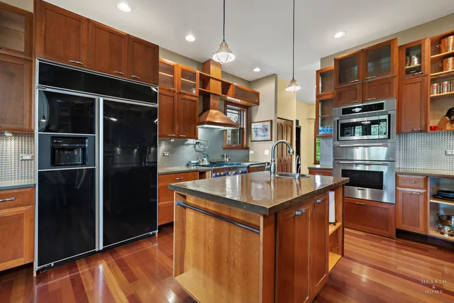 a kitchen with stainless steel appliances granite countertop wooden floors and sink