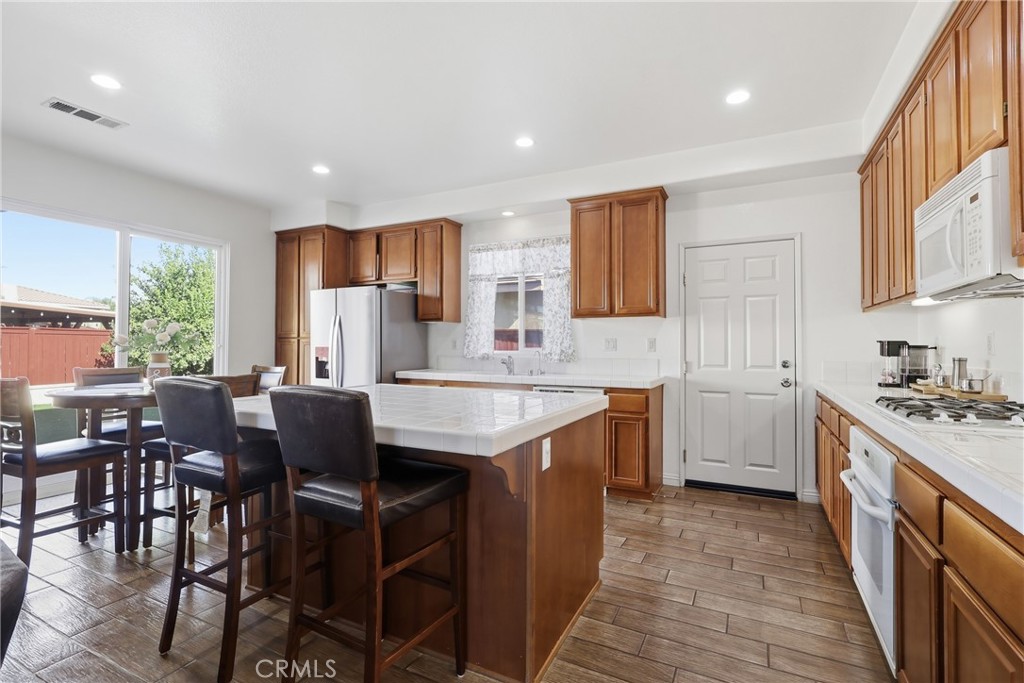 3609 Pyramid Trail Perris, CA 92570 - Photo 13 of 40 a kitchen with a table chairs sink and cabinets