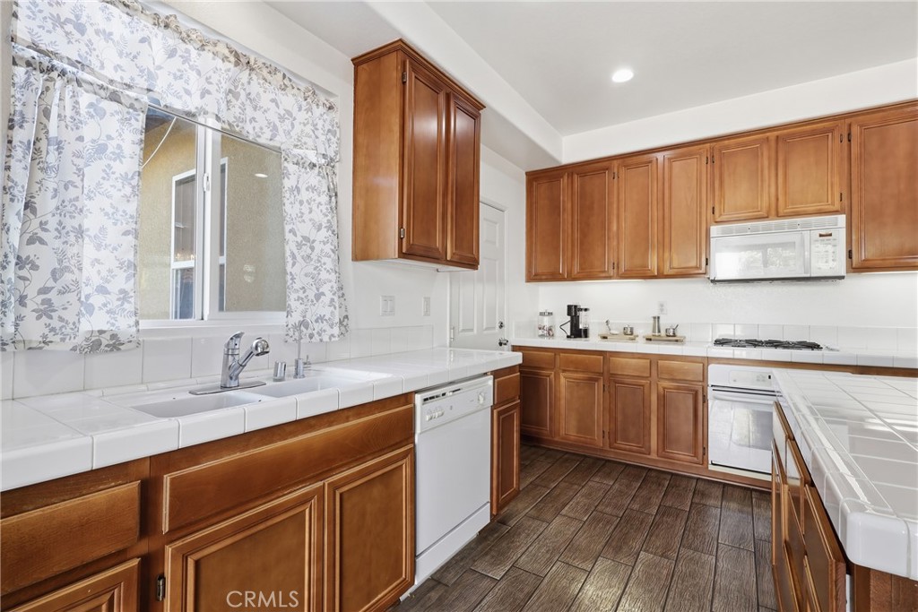 3609 Pyramid Trail Perris, CA 92570 - Photo 16 of 40 a kitchen with stainless steel appliances granite countertop wooden cabinets a sink and dishwasher a stove with wooden floor