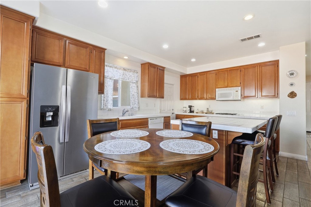 3609 Pyramid Trail Perris, CA 92570 - Photo 18 of 40 a kitchen with a table chairs refrigerator and cabinets