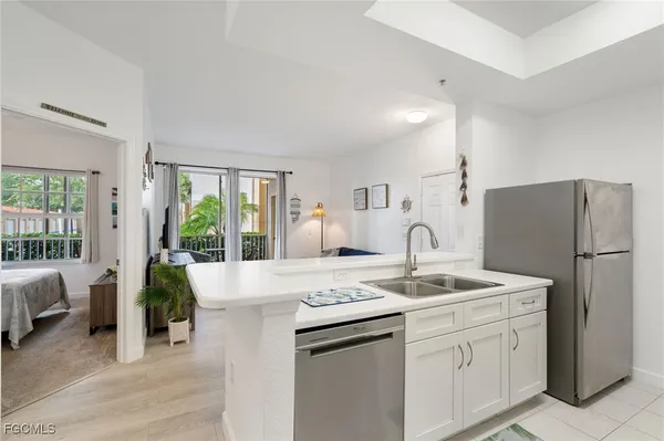 a kitchen with stainless steel appliances granite countertop a refrigerator sink and white cabinets