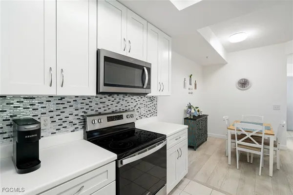 a kitchen with granite countertop white cabinets and stainless steel appliances