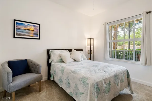 a bedroom with a bed couch and a large window