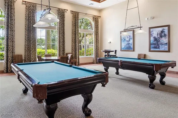 a room with pool table and windows