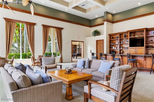 a living room with furniture a flat screen tv and a large window