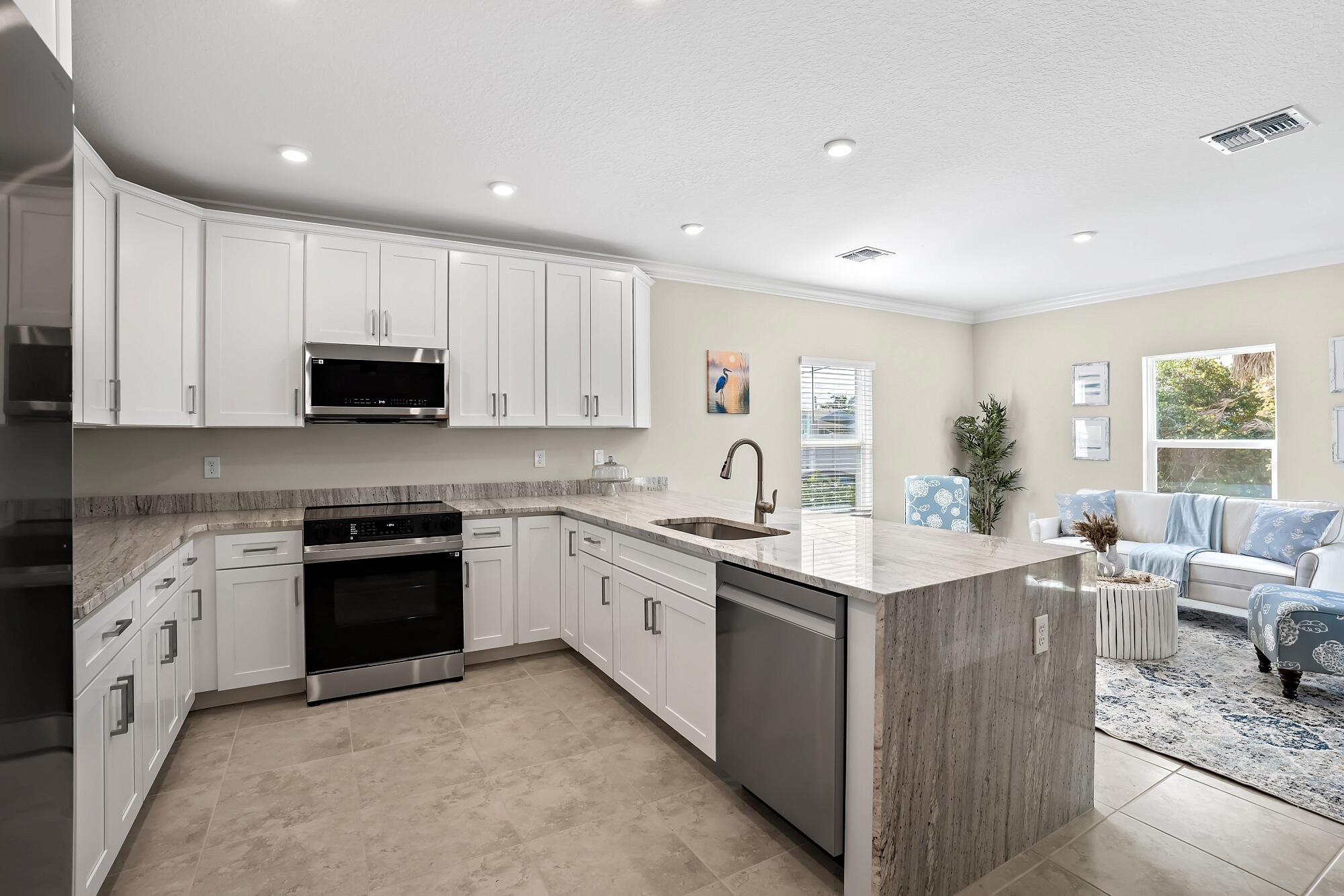 418 Easy Street Sebastian, FL 32958 - Photo 13 of 42 a kitchen with stainless steel appliances granite countertop a stove top oven a sink dishwasher and a refrigerator