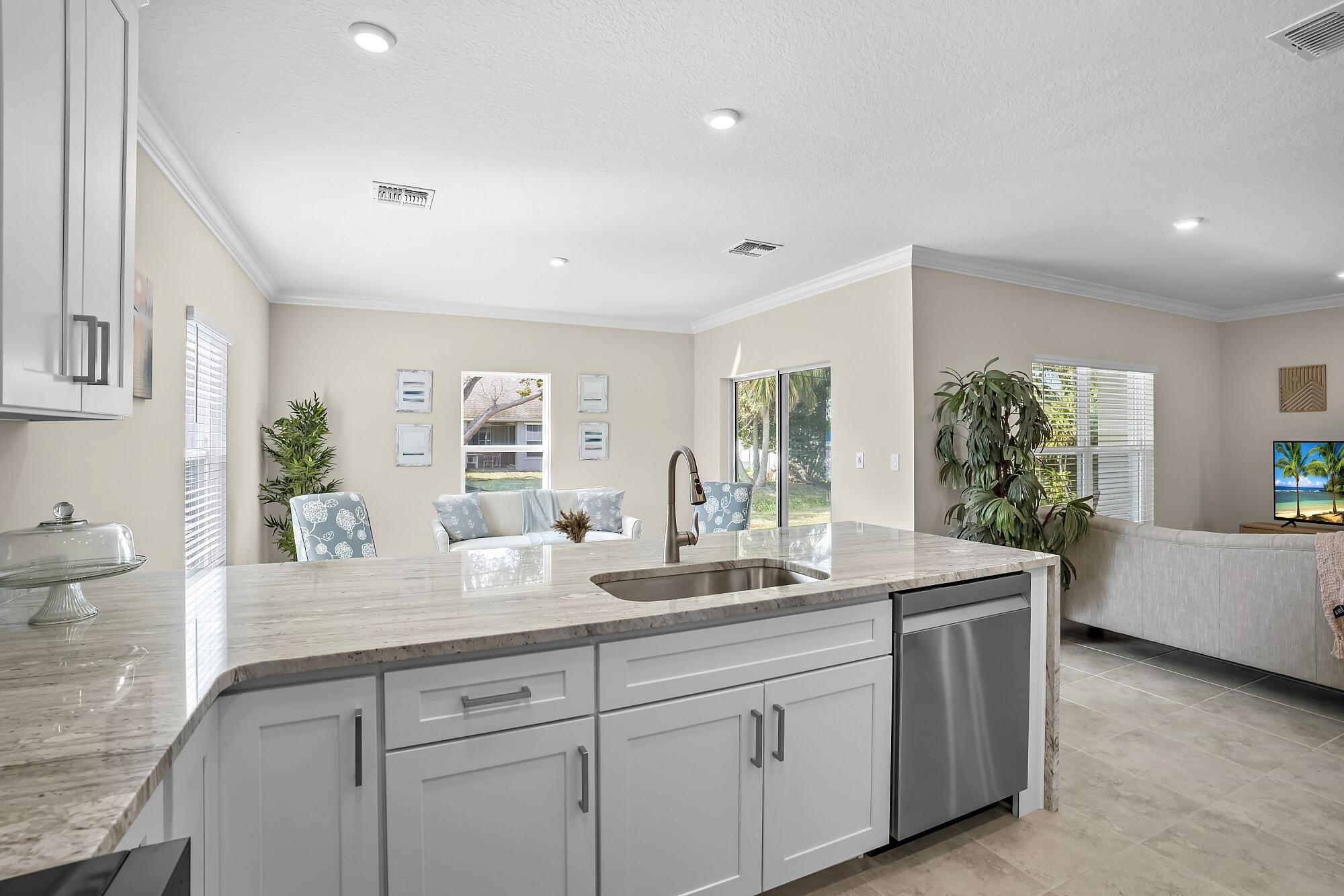 418 Easy Street Sebastian, FL 32958 - Photo 14 of 42 a dining hall with stainless steel appliances granite countertop a sink and dishwasher with wooden floor
