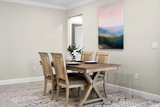a living room with stainless steel appliances furniture a rug and a kitchen view