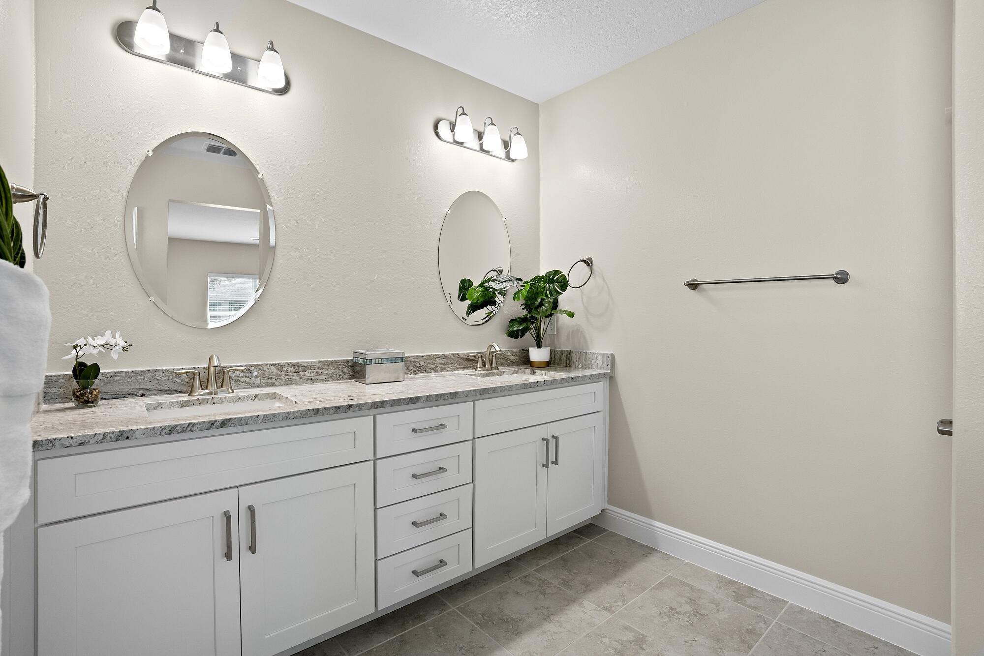 418 Easy Street Sebastian, FL 32958 - Photo 31 of 42 a bathroom with a granite countertop double sink and a mirror