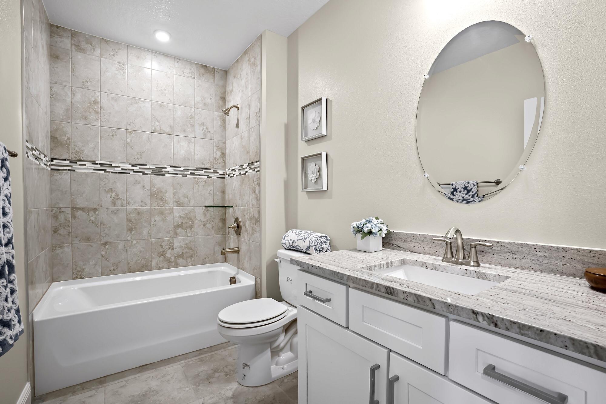 418 Easy Street Sebastian, FL 32958 - Photo 34 of 42 a bathroom with a granite countertop toilet a sink and bathtub