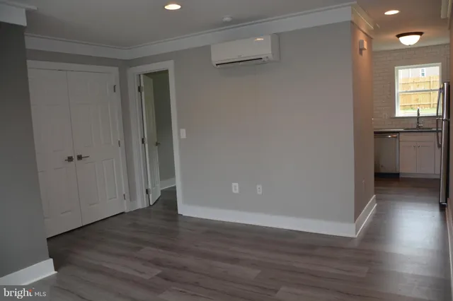 a view of a hallway with wooden floor and a living room