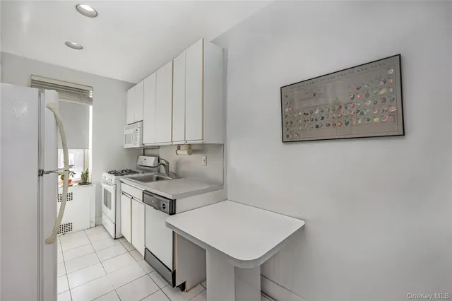 a kitchen that has a sink a stove and a refrigerator