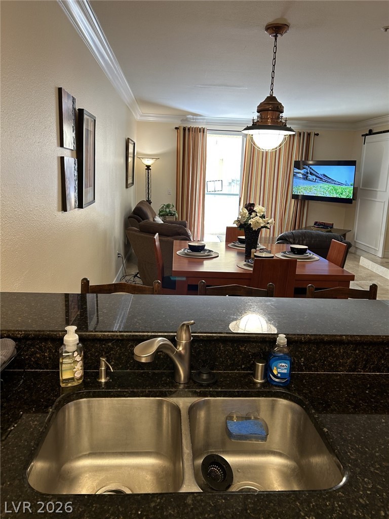 210 East Flamingo Road, Unit 137 Las Vegas, NV 89169 - Photo 7 of 32 Granite counters and dual sinks in this kitchen, flowing into an inviting dining and living space.