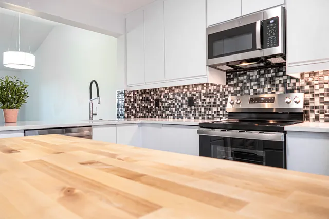 a kitchen with stainless steel appliances kitchen island granite countertop a stove and a sink
