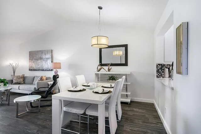 a living room with furniture a window and wooden floor