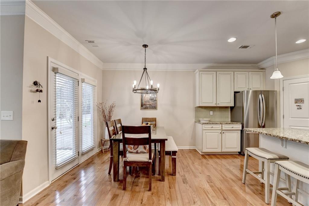 2455 Matlin Way Buford, GA 30519 - Photo 14 of 58 a kitchen with stainless steel appliances a dining table chairs refrigerator and cabinets