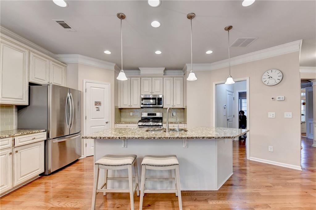 2455 Matlin Way Buford, GA 30519 - Photo 17 of 58 a kitchen with stainless steel appliances kitchen island granite countertop a refrigerator a stove and white cabinets with wooden floor