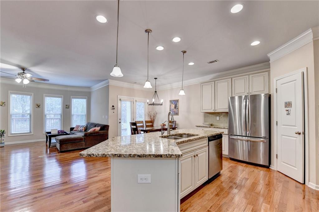 2455 Matlin Way Buford, GA 30519 - Photo 21 of 58 a kitchen with stainless steel appliances granite countertop a refrigerator a sink dishwasher a kitchen island with wooden cabinets and wooden floor