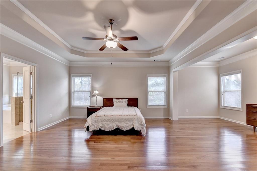 2455 Matlin Way Buford, GA 30519 - Photo 32 of 58 a bedroom with a bed and wooden floor