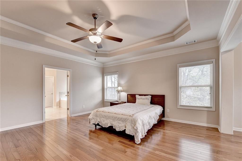 2455 Matlin Way Buford, GA 30519 - Photo 33 of 58 a bedroom with a large bed chandelier and a window