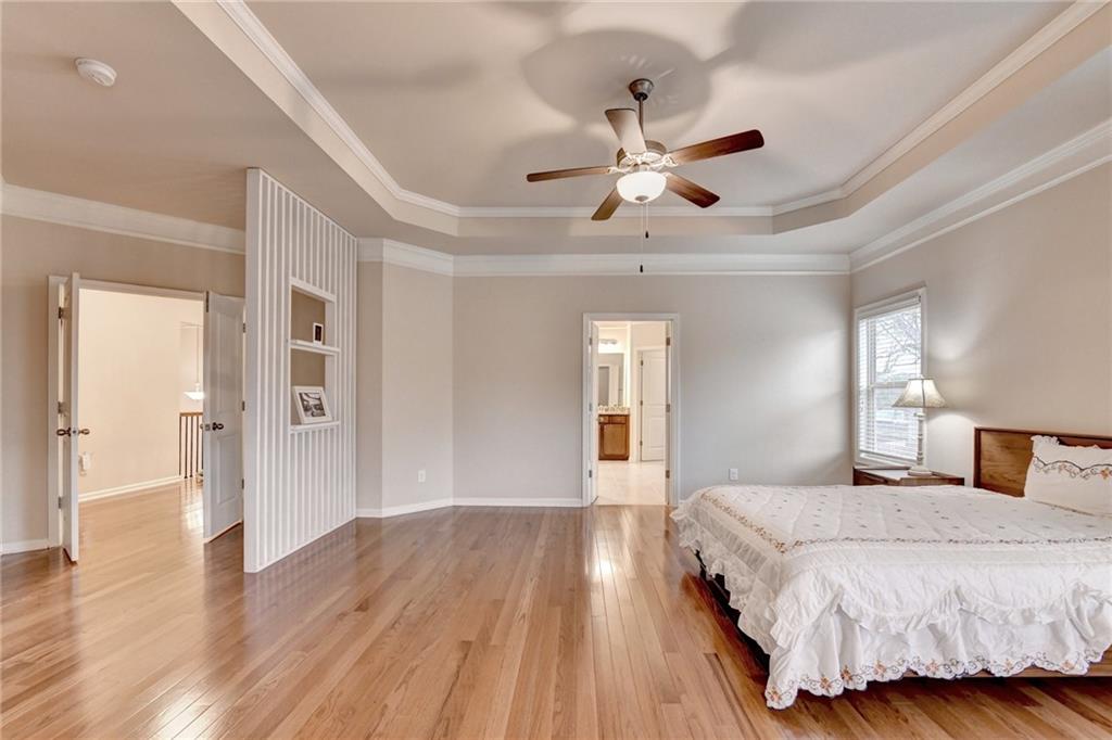 2455 Matlin Way Buford, GA 30519 - Photo 34 of 58 a spacious bedroom with a large bed chandelier and a window