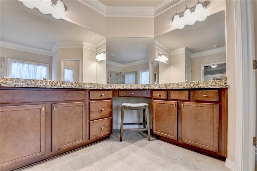 2455 Matlin Way Buford, GA 30519 - Photo 37 of 58 a bathroom with a sink a mirror and a cabinets