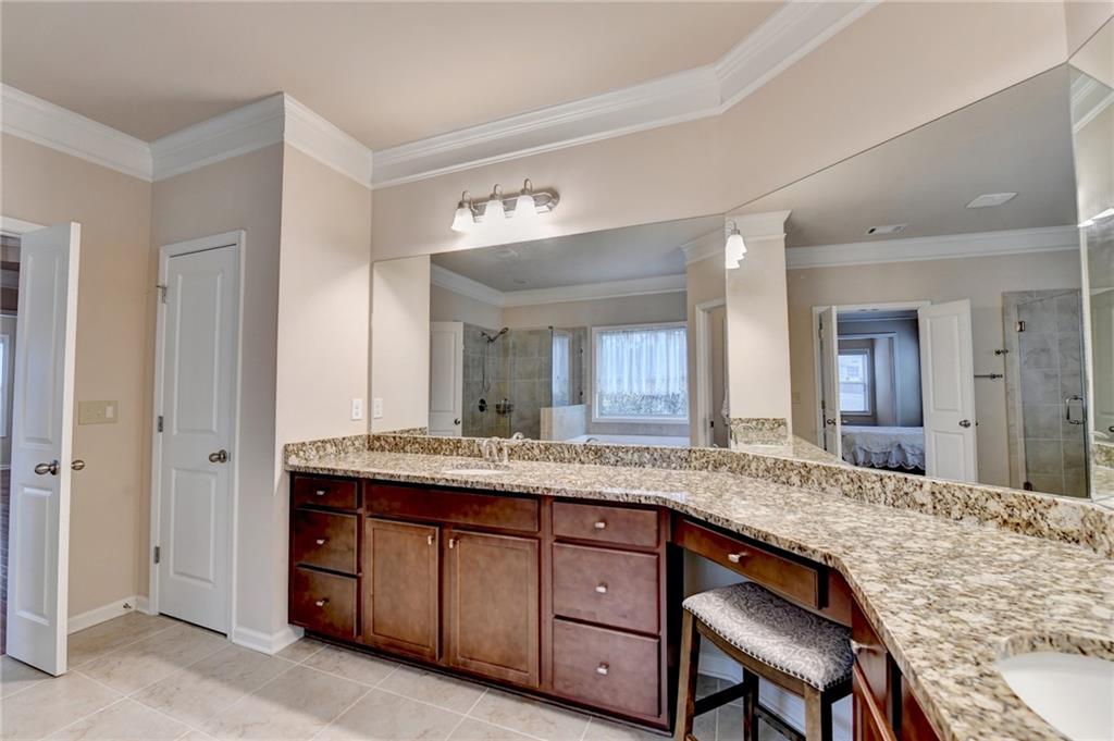 2455 Matlin Way Buford, GA 30519 - Photo 38 of 58 a bathroom with a granite countertop sink and a mirror