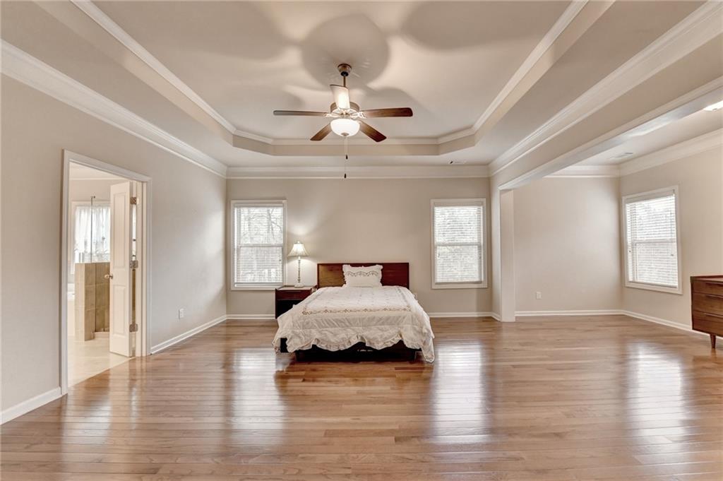 2455 Matlin Way Buford, GA 30519 - Photo 41 of 58 a spacious bedroom with a bed mirror and window