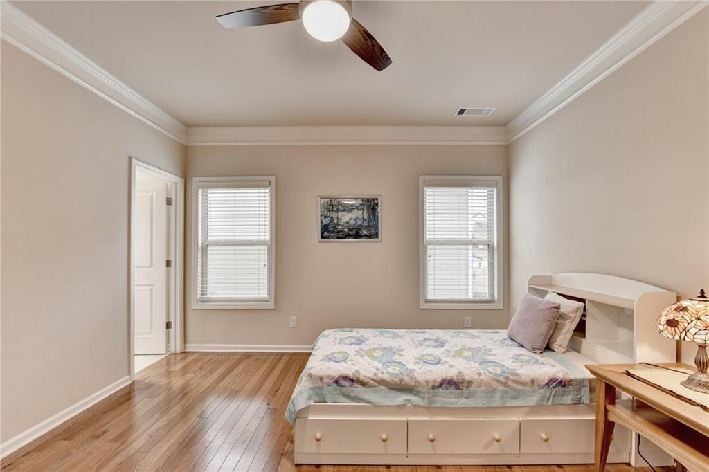 2455 Matlin Way Buford, GA 30519 - Photo 43 of 58 a bedroom with a bed and wooden floor