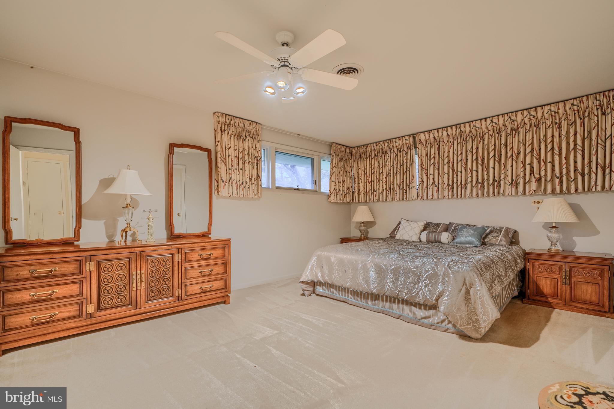 7900 Ivy Lane Baltimore, MD 21208 - Photo 17 of 32 a spacious bedroom with a bed a dresser and potted plant on the dresser
