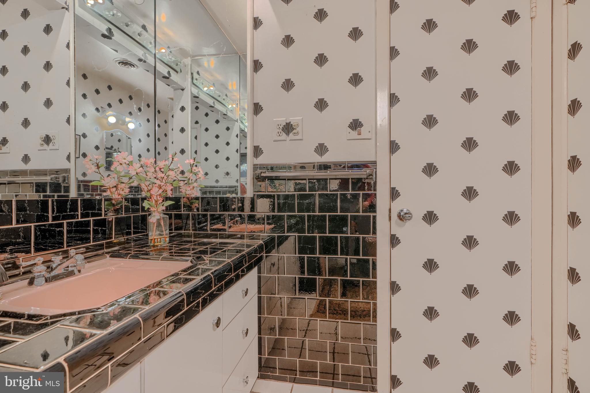 7900 Ivy Lane Baltimore, MD 21208 - Photo 22 of 32 a bathroom with a granite countertop sink a toilet and shower