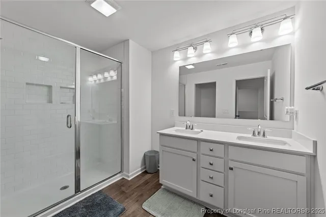 a bathroom with a double vanity sink mirror and shower