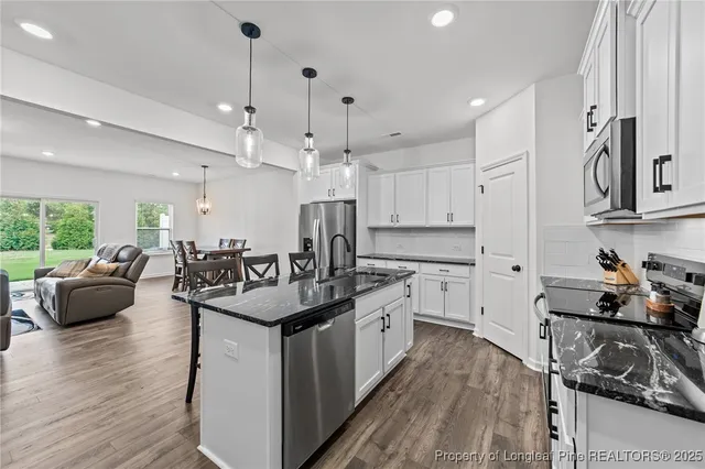 a kitchen with counter space sink stove and wooden floor