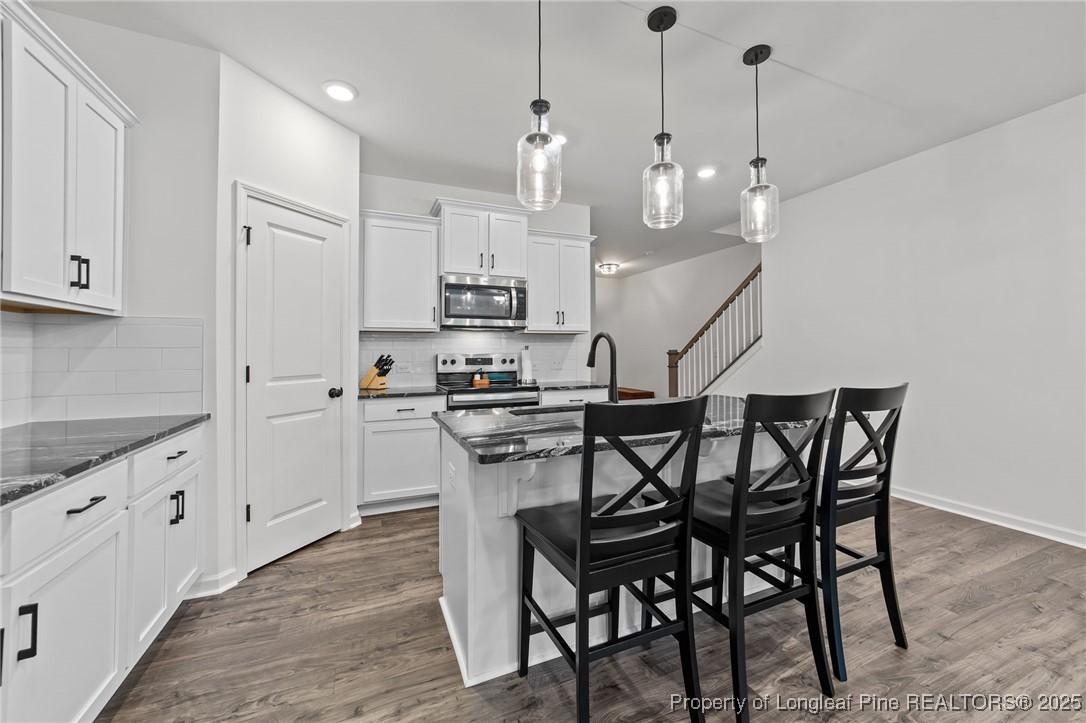 96 Periwinkle Place Clayton, NC 27527 - Photo 6 of 19 a kitchen with stainless steel appliances a white table chairs refrigerator and cabinets