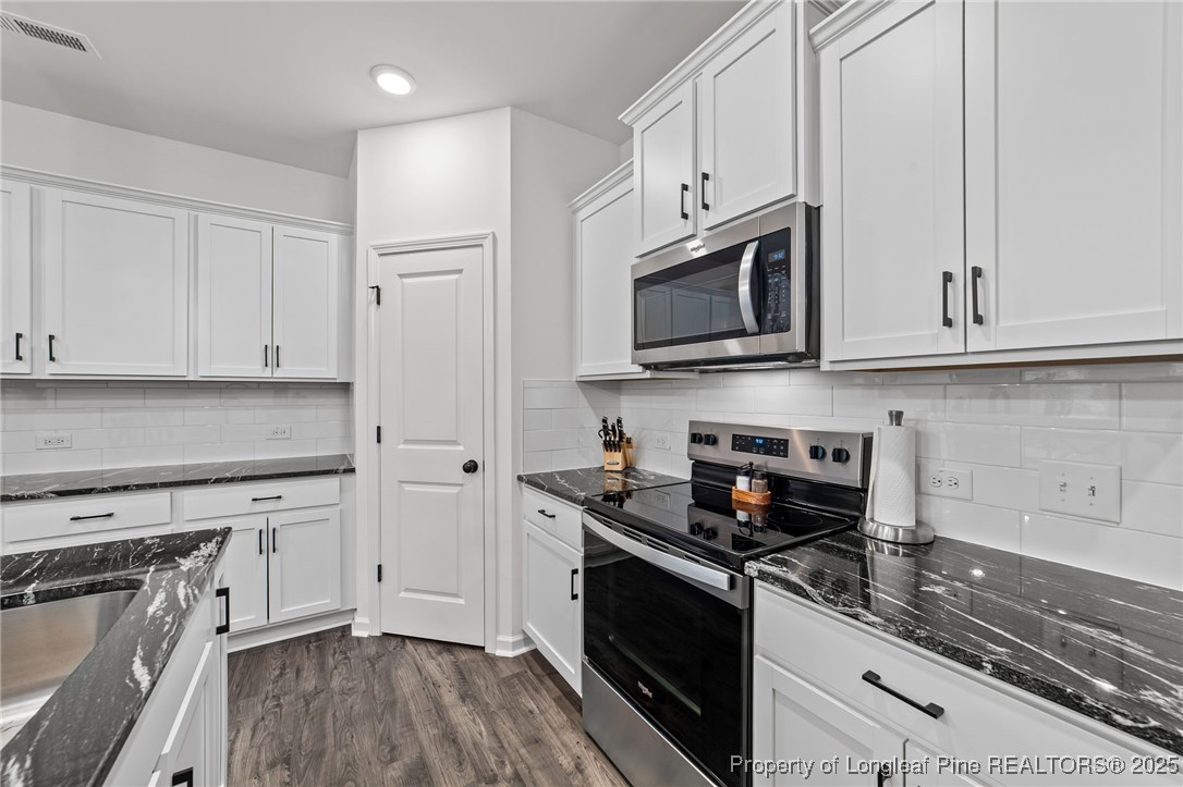 96 Periwinkle Place Clayton, NC 27527 - Photo 7 of 19 a kitchen with stainless steel appliances granite countertop white cabinets granite counter tops and a stove