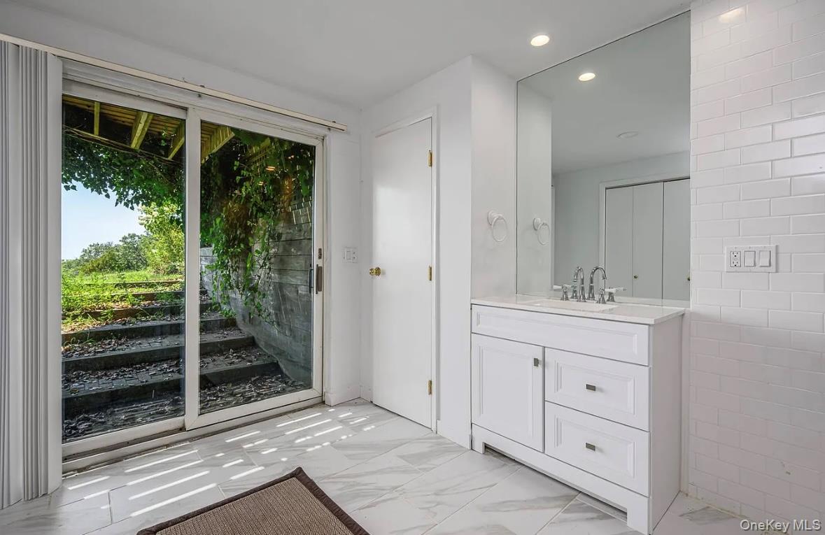 972 Noyac Path Water Mill, NY 11976 - Photo 34 of 40 a bathroom with a shower sink and mirror