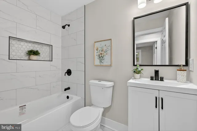a white toilet sitting next to a bathroom sink and tub
