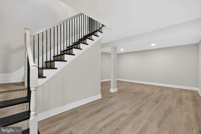 a view of staircase with wooden floor and white walls