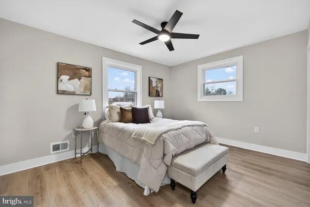 a spacious bedroom with a bed and a painting on the wall