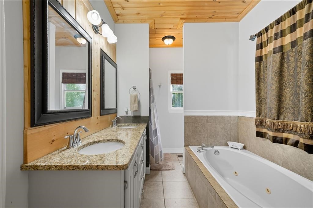 491 Hyde Road Jasper, GA 30143 - Photo 18 of 60 a bathroom with a granite countertop tub sink and mirror