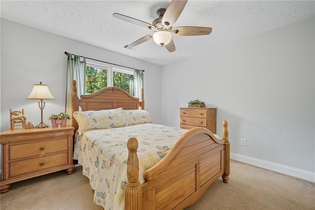 491 Hyde Road Jasper, GA 30143 - Photo 30 of 60 a bedroom with a bed and a chandelier