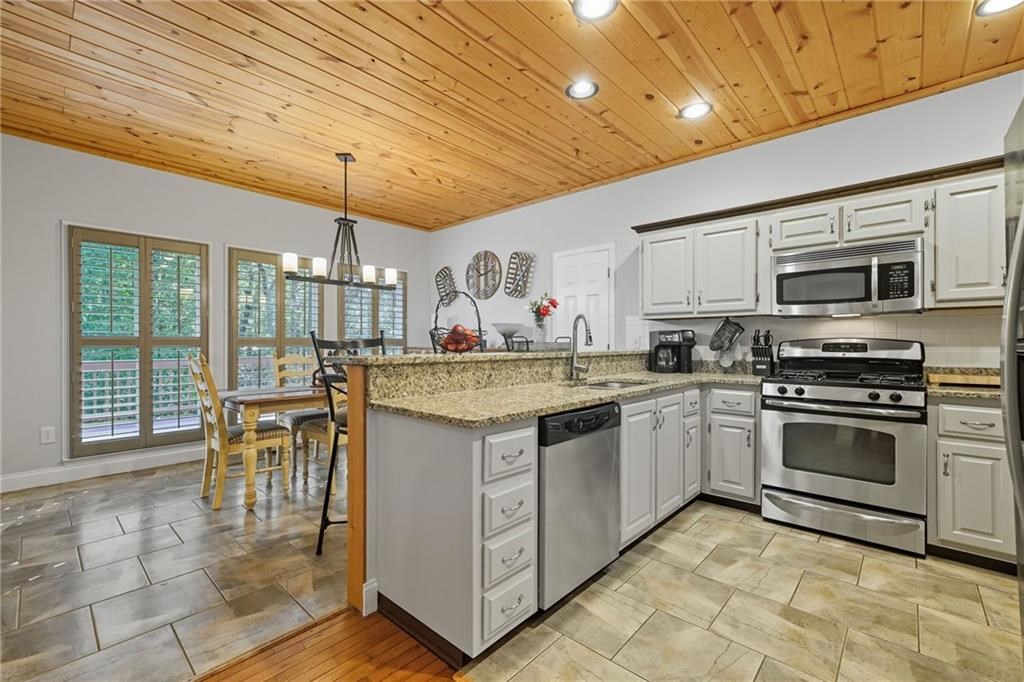 491 Hyde Road Jasper, GA 30143 - Photo 8 of 60 a kitchen with stainless steel appliances granite countertop a stove top oven a sink dishwasher a dining table and chairs with wooden floor