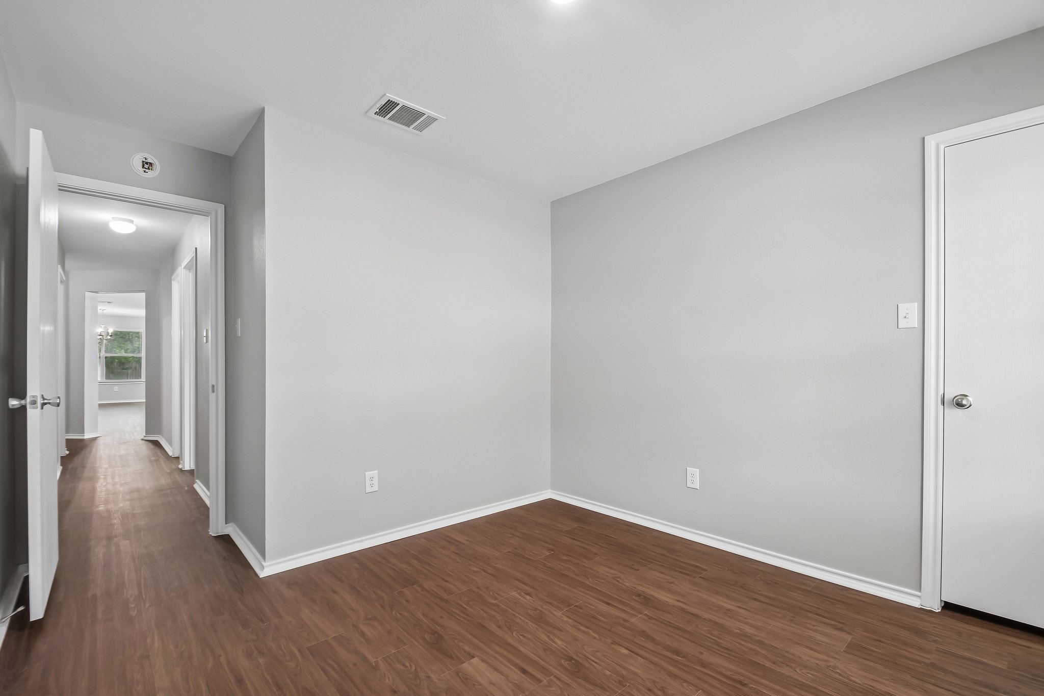 610 Lavaca Loop Elgin, TX 78621 - Photo 28 of 37 Rich wood-look flooring extends through this room and into the adjoining hallway, creating a unified flow.