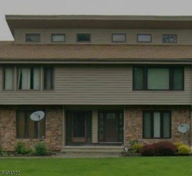 a view of a stone house with a small yard